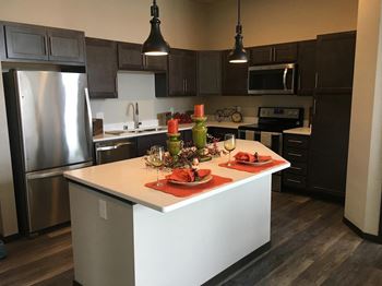 A modern kitchen with a white island and stainless steel appliances.